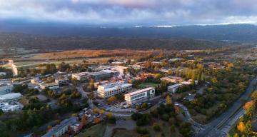 Aerial view of the SLAC site showing Sand Hill Road and main entrance in the bottom right and rolling hills in the background